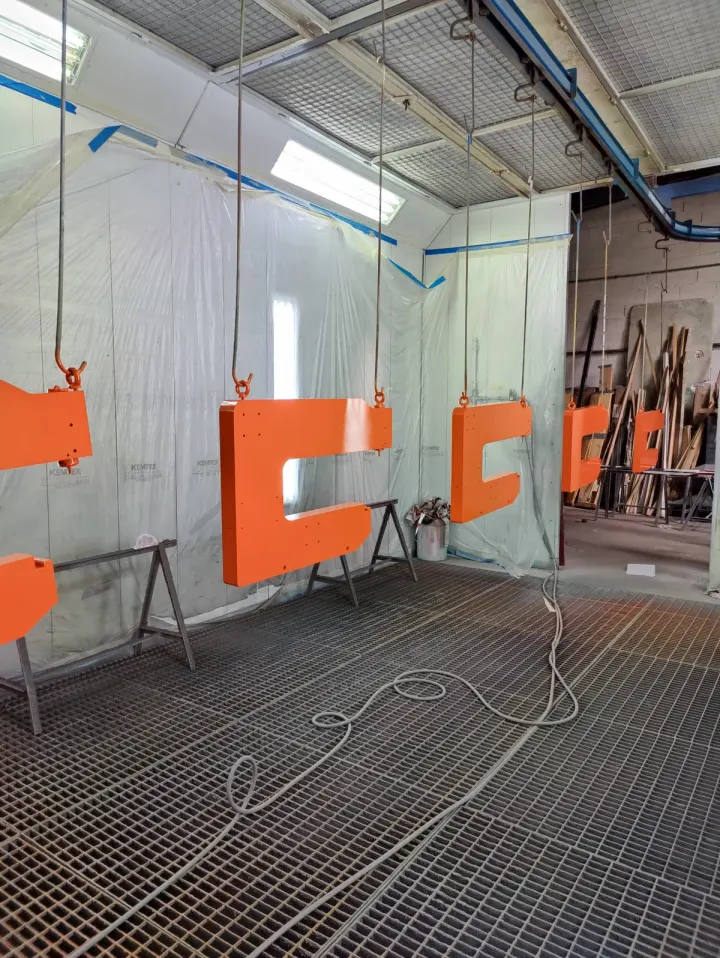Pièces suspendues dans la cabine de peinture SIRPE